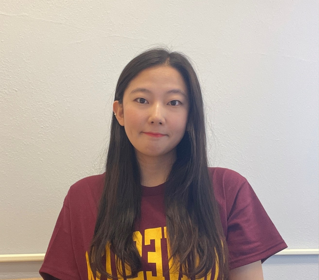 Portrait picture of Eunyoung Park in a UMN maroon shirt in front of a white wall 